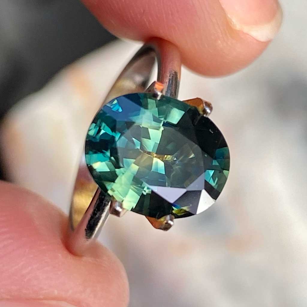 Oval Australian parti sapphire displaying blue, green and yellow colours, available to set in a bespoke engagement ring, by Sydney jeweller Lizunova