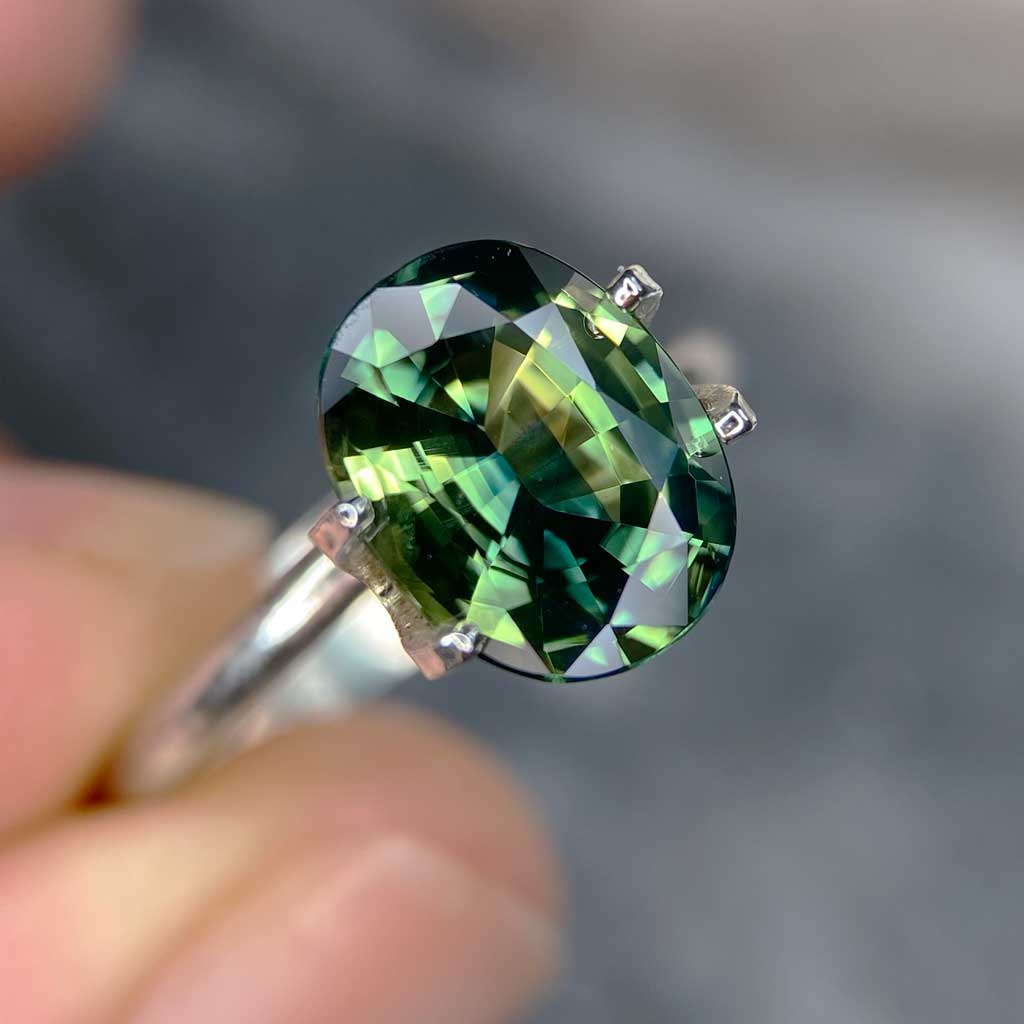 Oval Australian parti sapphire in blue, green, yellow colours, available to set in a sapphire engagement ring by Sydney jeweller Lizunova