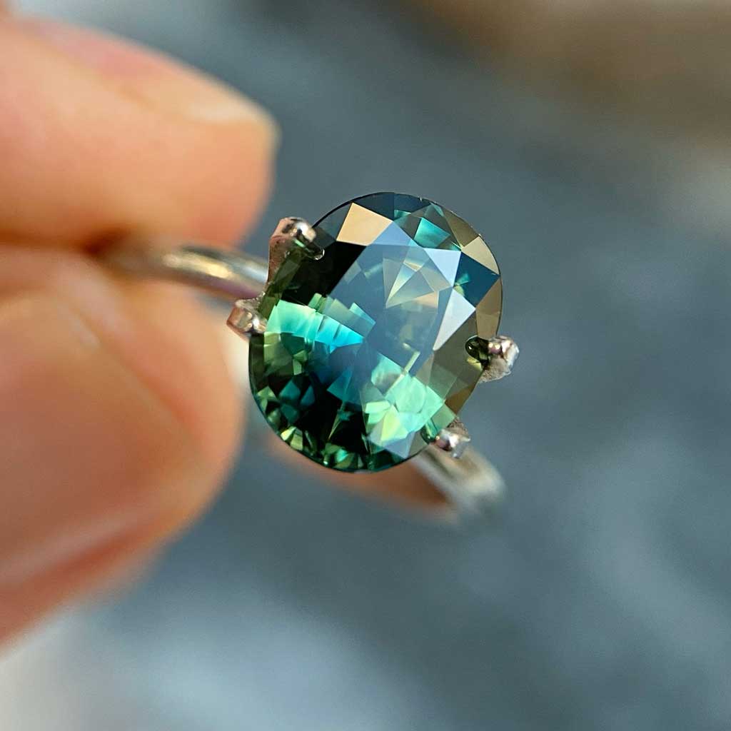 Oval Australian parti sapphire in blue, green, yellow colours, available to set in a sapphire engagement ring by Sydney jeweller Lizunova