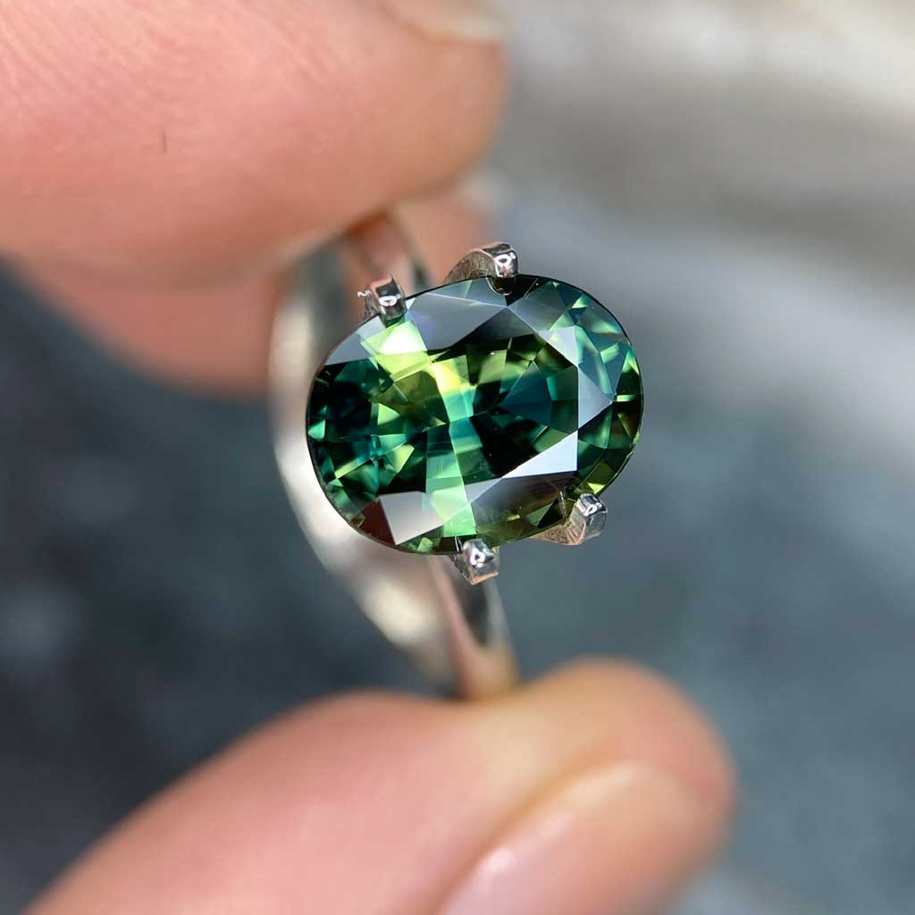Oval Australian parti sapphire in blue, green, yellow colours, available to set in a sapphire engagement ring by Sydney jeweller Lizunova