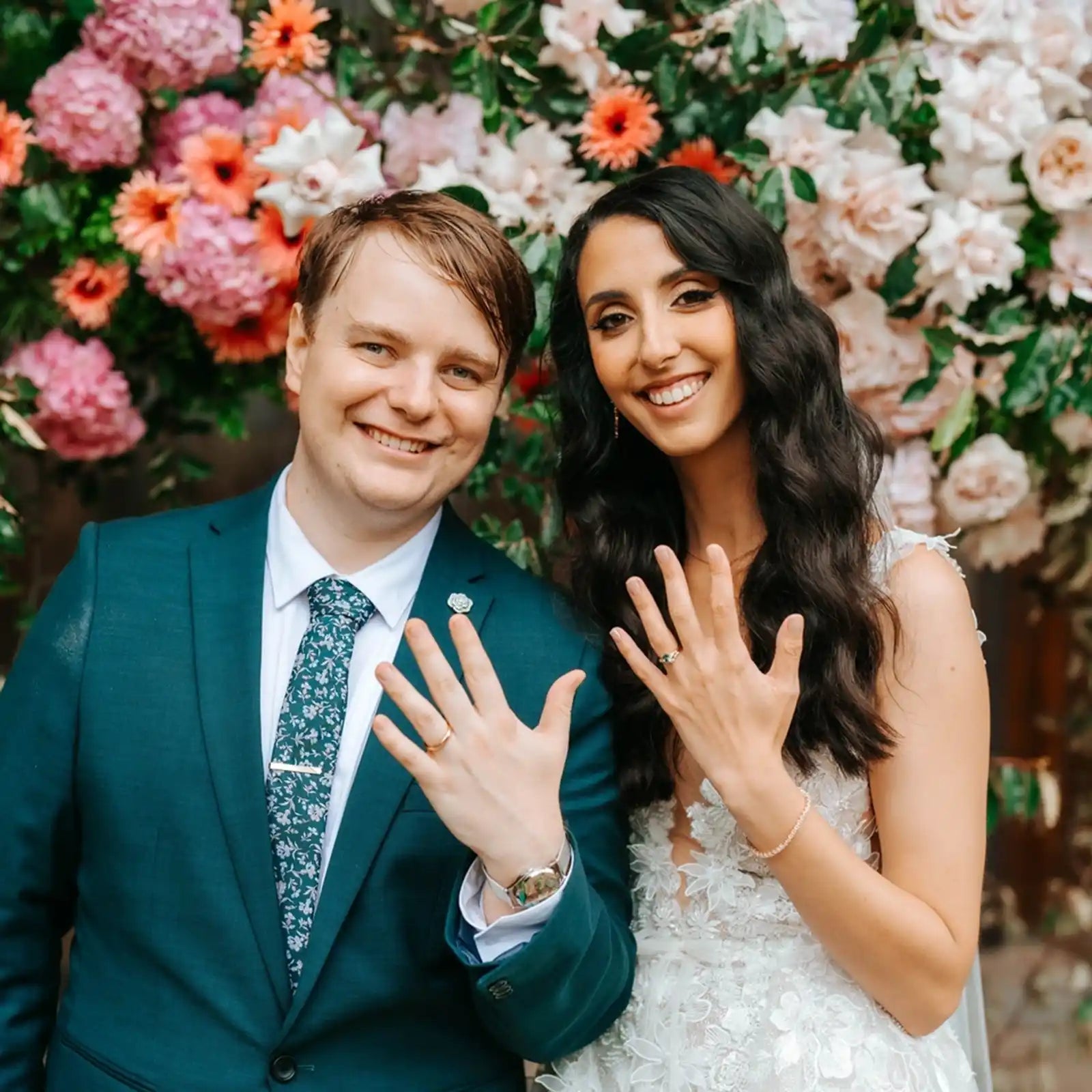 Happy customers of Lizunova Fine Jewels on their wedding day, showing off their bespoke engagement and wedding rings