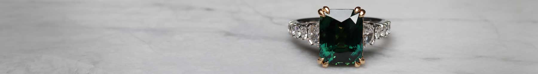 A bespoke teal sapphire and diamond engagement ring handcrafted in Sydney by Lizunova Fine Jewels