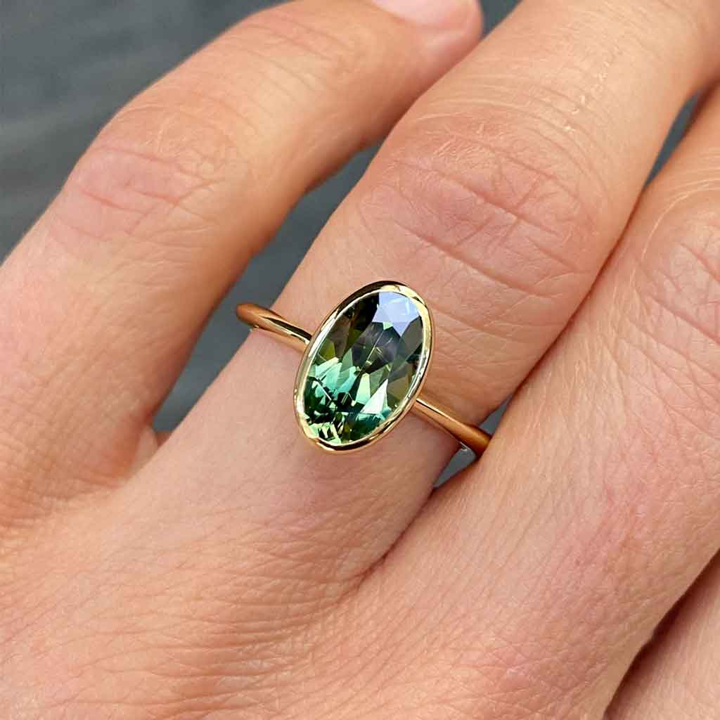 Bezel set oval Australian green teal sapphire engagement ring, Sydney jeweller Lizunova