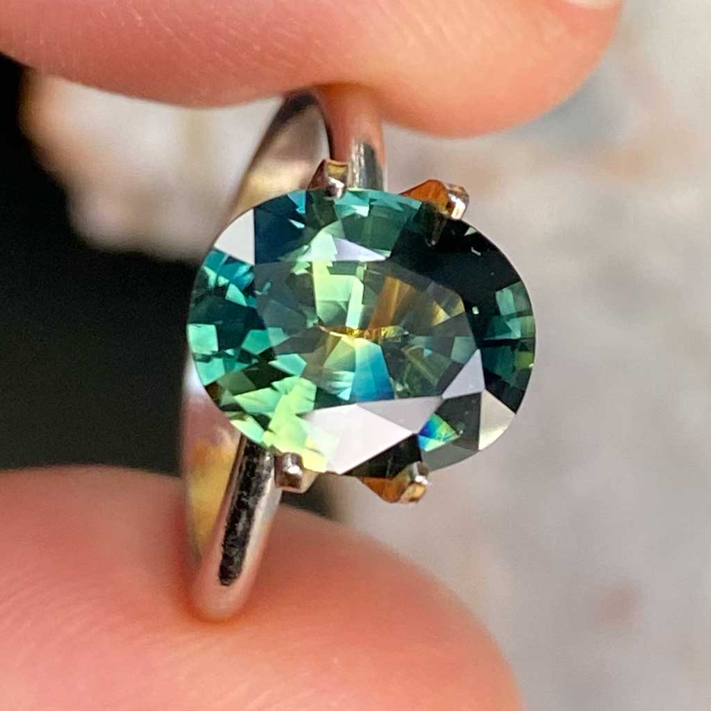 Oval Australian parti sapphire displaying blue, green and yellow colours, available to set in a bespoke engagement ring, by Sydney jeweller Lizunova
