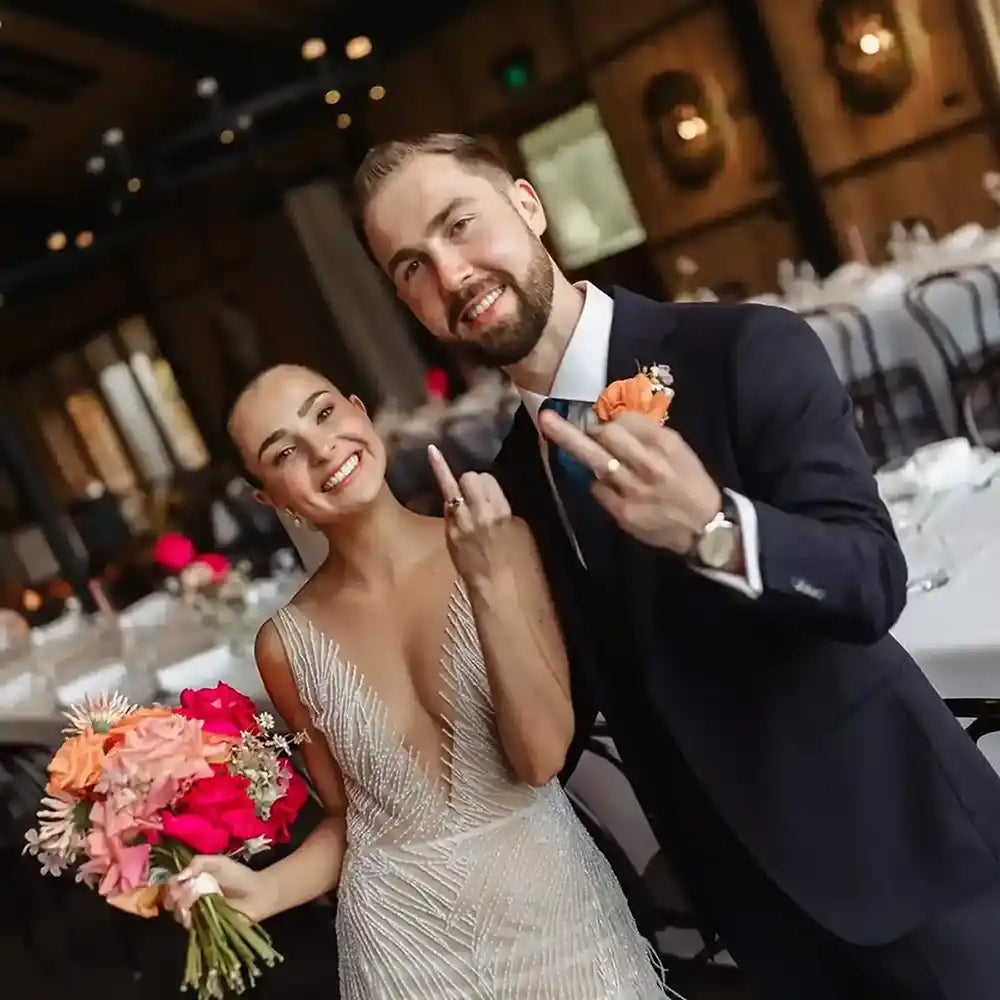 Happy customers of Lizunova Fine Jewels on their wedding day, showing off their bespoke engagement and wedding rings