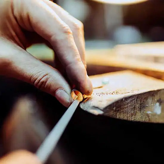 Jeweller at bench working on a gold wedding ring, Sydney jeweller Lizunova