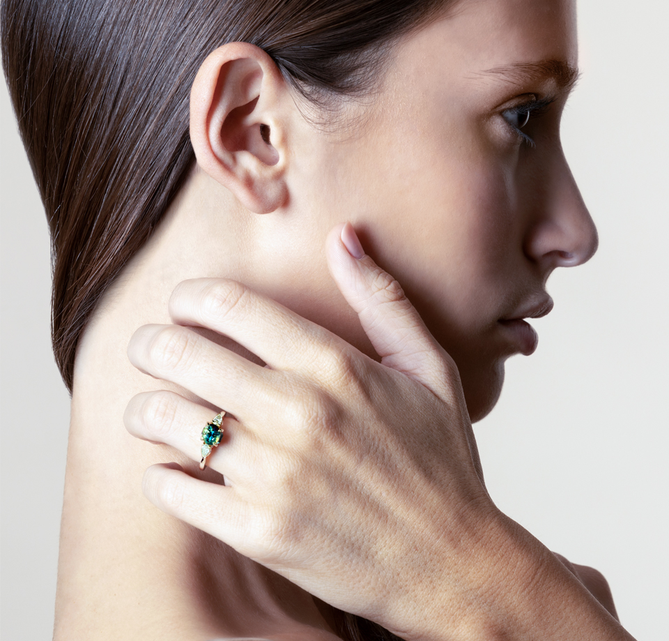 woman-hand-on-neck-with-Australian-teal-parti-sapphire-ring